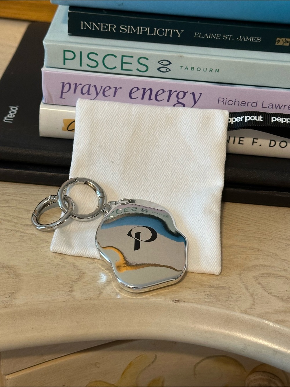 Pepper Pout Pebble-shaped Silver Keychain with 'P' Logo